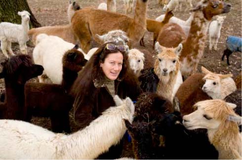 Angel Forbes-Simmons poses with her beloved alpaca and llama herd